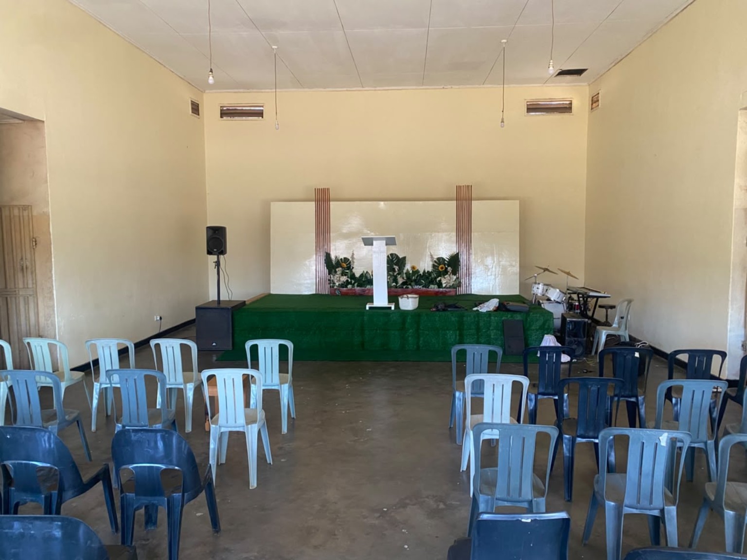 The church hall with rows of chairs facing the green platform.