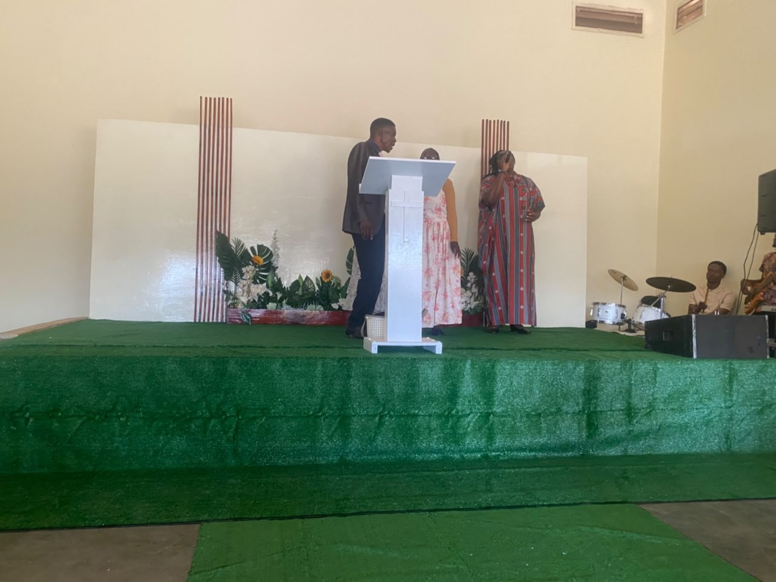 Two speakers standing beside the lectern at the front of the church.